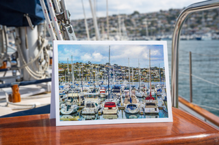 Framed photograph of a marina on a boat deck with water and skyline in the background