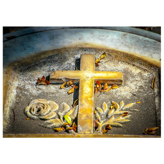 Decorative stone with a cross, rose, and leaves on a white background. Photo by Matt Punches