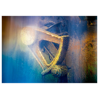 Rusted metal gear underwater with light shining on it