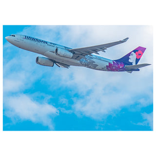 Hawaiian Airlines airplane flying against a blue sky with clouds