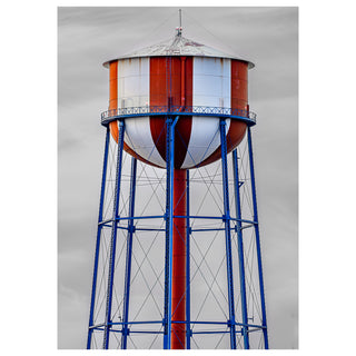 Red and white striped water tower with blue metal structure against a gray sky