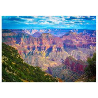 Colorful panoramic view of the Grand Canyon with layered red and purple rock formations, dramatic cliffs, green foreground vegetation, and a partly cloudy blue sky.