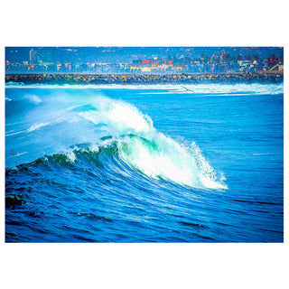 Wave crashing in the foreground with a city skyline in the background