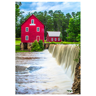 Red mill with a waterfall in a forested area