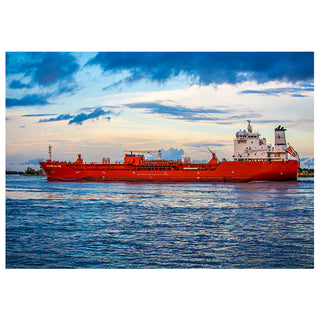 Red cargo ship sailing on a body of water with a blue sky and clouds in the background