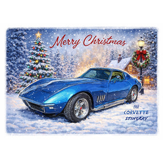 Fine art greeting card featuring a stunning illustration of a gleaming cobalt blue 1968 Corvette Stingray dusted with fresh snow in a magical Christmas evening scene, with a glittering snow-laden decorated Christmas tree, a warm glowing cottage, and a festive wreath-adorned lamp post, with Merry Christmas in elegant red script above and 1968 Corvette Stingray lettering in blue below, 5x7 greeting card with envelope by Will Davis Studios.