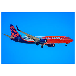 Sun Country Airlines airplane against a clear blue sky Will Davis Studios