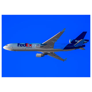 FedEx airplane flying against a blue sky photo by Matt Punches