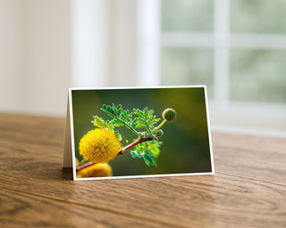 Greeting card with a yellow flower on a wooden surface
