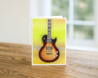 Greeting card with a guitar design on a wooden surface will davis studios