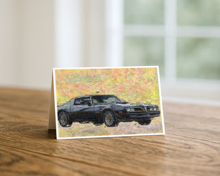 Greeting card with a black trans am car on a wooden surface
