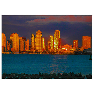 City skyline at night with illuminated buildings reflected in water photo by Matt Punches