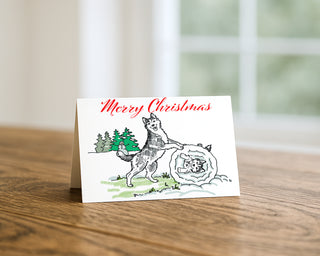Christmas card with a dog and tree design on a wooden surface