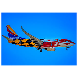 Southwest Airlines airplane in flight against a blue sky Will Davis Studios