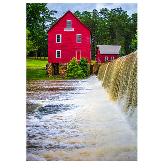 Red mill with a waterfall in front, surrounded by trees photo by Matt Punches