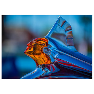 Close-up of a shiny metal car hood ornament with a blue and orange color scheme. Pontiac Will Davis Studios