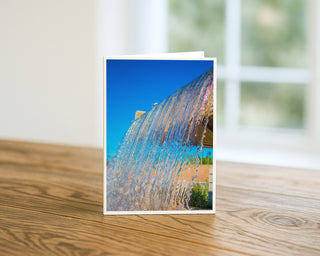Greeting card with a water fountain design on a wooden surface by Will Davis Studios