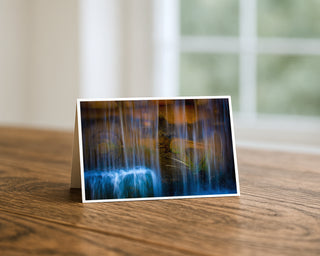Greeting card with a watercolor design of a waterfall on a wooden surface.