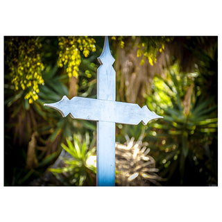 Decorative wood cross in a natural setting with greenery