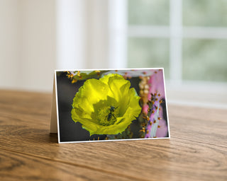 Greeting card with a yellow flower and bee on a wooden surface by Will Davis Studios